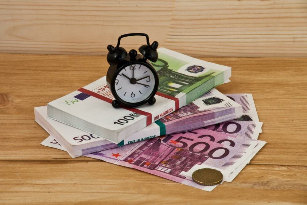 Alarm clock and bundle of bank notes: picture symbolizing the advantages of SEO-optimized translation